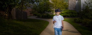 Spring Semester, man with mask walking down path