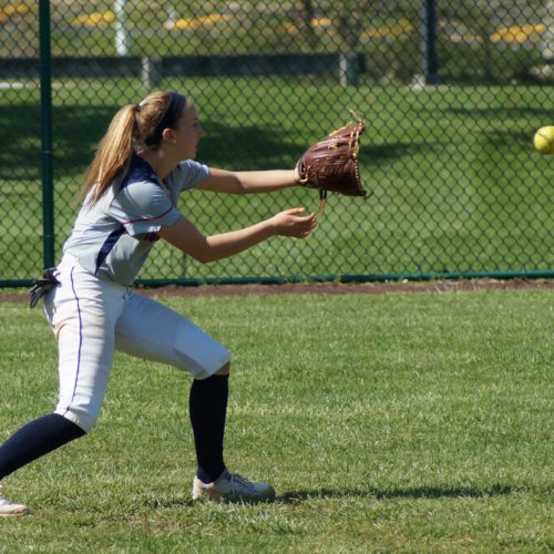 softball player catching ball in the field