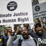 Black men holding signs that say Climate Justice is a Human Right