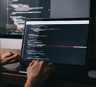 Young caucasian female programmer in glasses writes program code on a laptop computer. home office. High quality photo