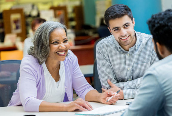 Woman talking to two students