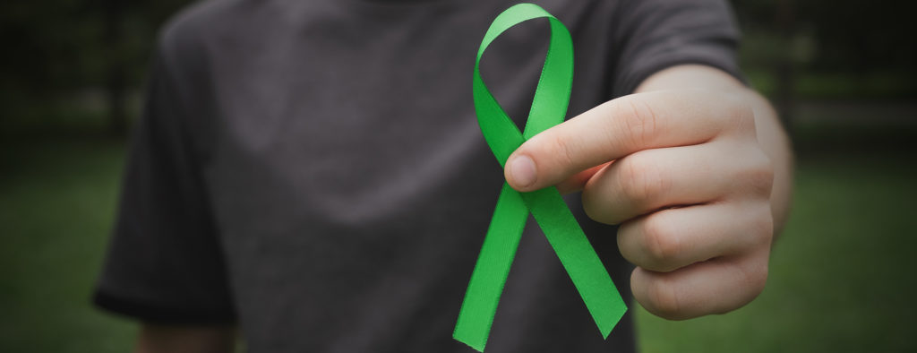 Man holding green ribbon in his hand