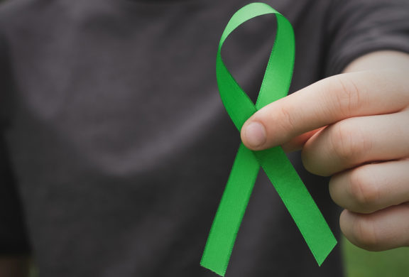 Man holding green ribbon in his hand
