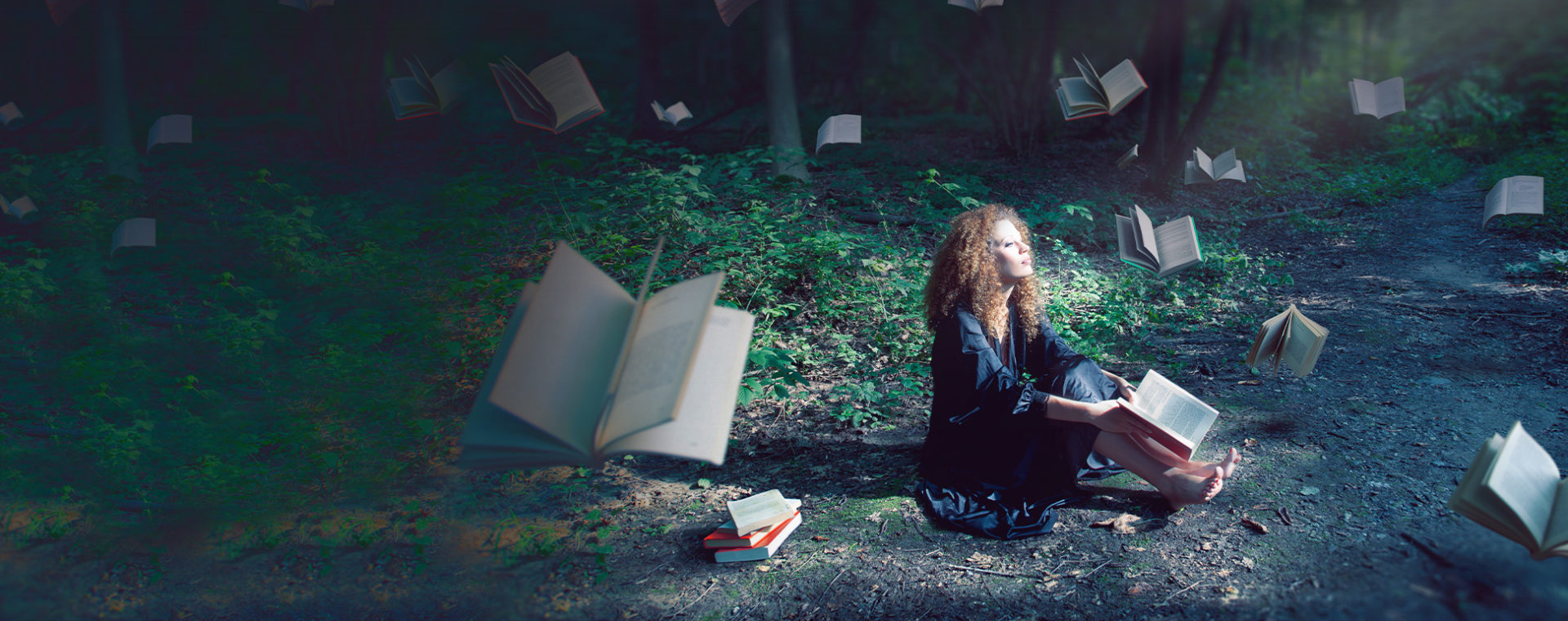Picture of a woman sitting on a lawn with books flying around her.