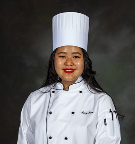 Aimy Sato in her chef had and coat.