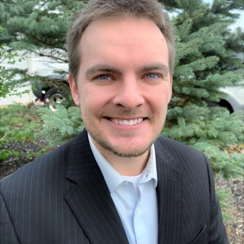 Austin Smith smiling with blue blazer and light blue shirt on.