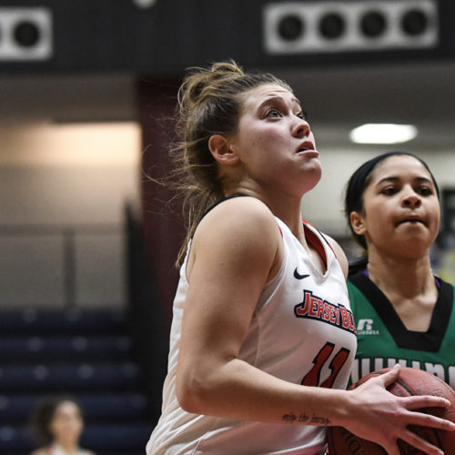 Woman with a basketball about to do a layup