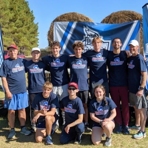 Full cross country team at National competition, 7 men, 1 woman, 2 coaches with their Brookdale t-shirts on and navy blue shorts.