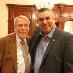 two men together in embrace for a photo, Professor Marshall and Dr. Stout in suit and ties smiling