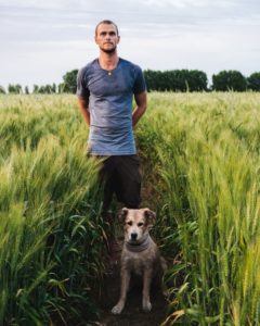 Tom Turcich and his dog in a field