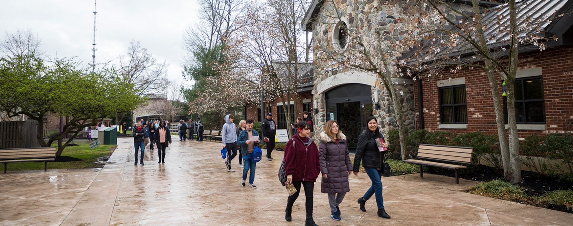 students walking down a path and in front of the student center on campus