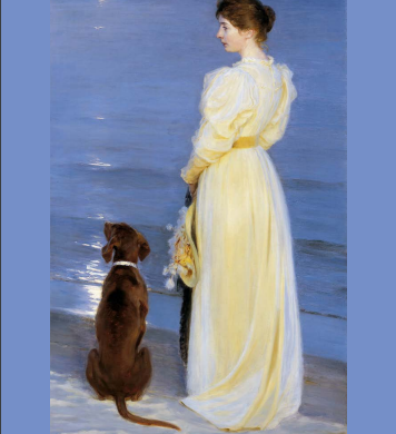 woman wearing a long yellow dress, standing on the sand facing the water with an umbrella in her hand and a black dog by her side