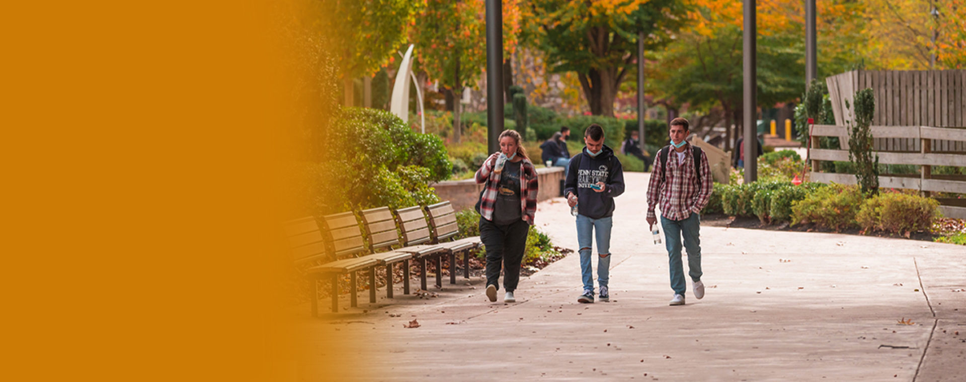 Three students walking down the path on campus