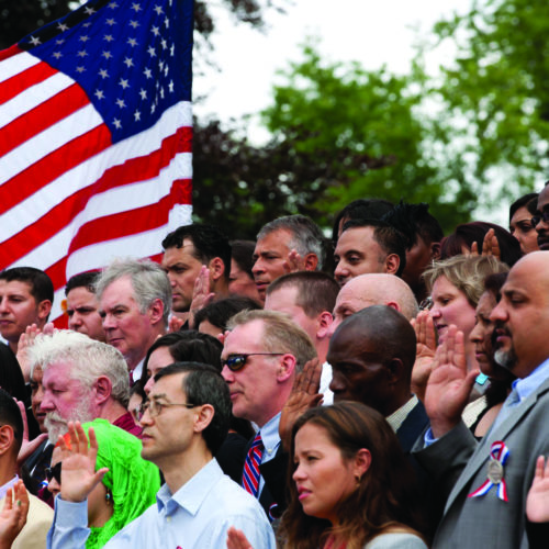 group of people and an American Flag waving in the crowd