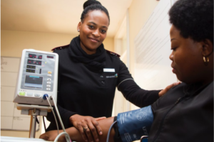 female technician taking blood pressure of patient