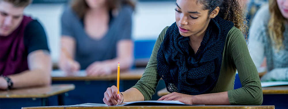 Student from high school sitting in a college class room.