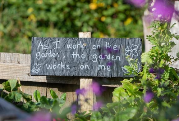 A chalkboard garden sign in the garden.