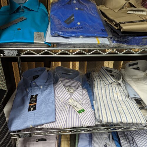 Button down shirts on three shelves.