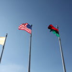 Three flags flying and blowing in the wind. American, Pan-African and Monmouth County Flags.