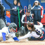 Women's softball photo of catcher tagging runner out at homeplate.