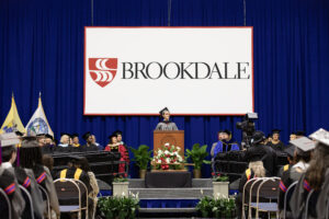 Student speaking at Commencement ceremony on stage at the podium.