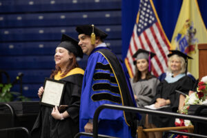 Outstanding Alum receiving award from President Dr. David M. Stout at Commencement ceremony.