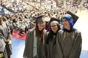 Three women in grey caps and gowns.