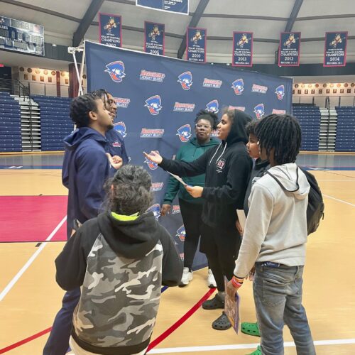 College basketball players talking to middle school boys and girls about perserverance.