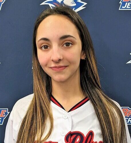 Female with long brown hair wearing a softball jersey.