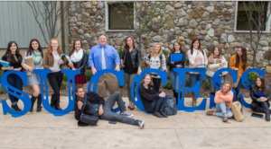 Large group of students standing in front and behind the SUCCESS sculpture on campus.