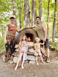 Lauren, Camilo and family in front of clay stove.