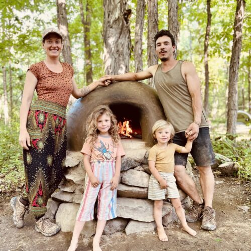 Lauren, Camilo and family in front of clay stove.