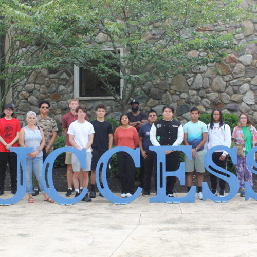 Group of students standing behind the Success sculpture.