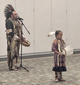 Native American adult male and child in full regalia.