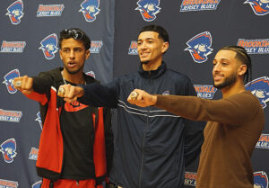 Three guys showing off their rings.