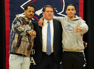 Two players and coach showing off their rings.