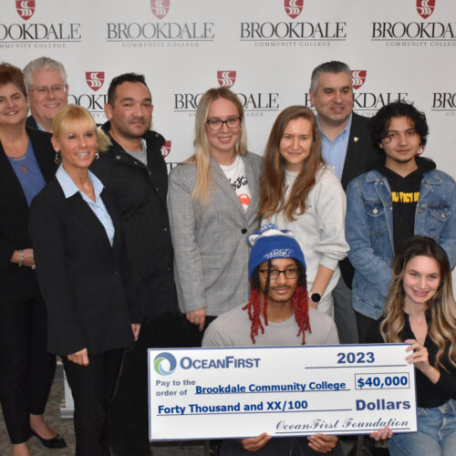 Group of students and bank officials holding a large check for $40,000