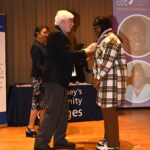 Eden Pela receives medal from Michael Gorman