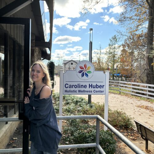 Woman opening the door at the entrance of the Caroline Huber Holistic Wellness Center.