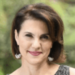 woman with medium length brown hair and brown eyes. Smiling red lips.