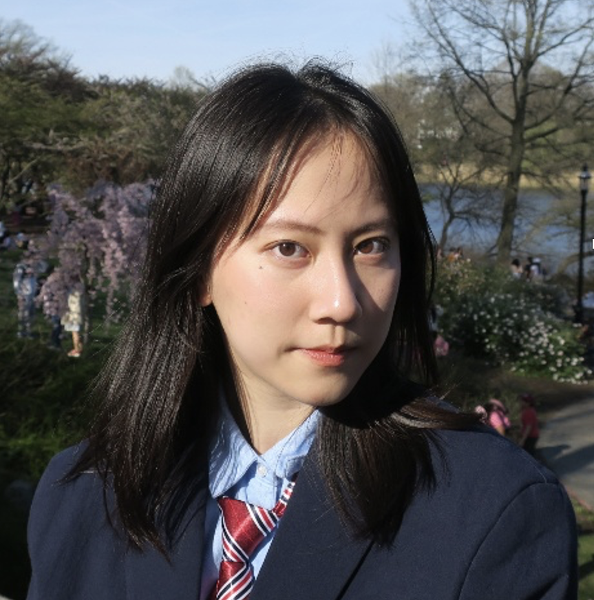 Jingran Xu wearing a navy blazer, red striped tie and light blue shirt. She has dark hair.