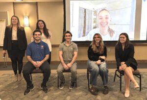 Five NASA Interns sitting on chairs and one on the screen.