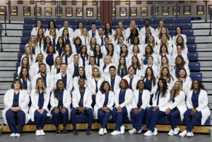 Brookdale Community College Nurse Pinning Fall 2025 graduates sitting together on the bleachers.